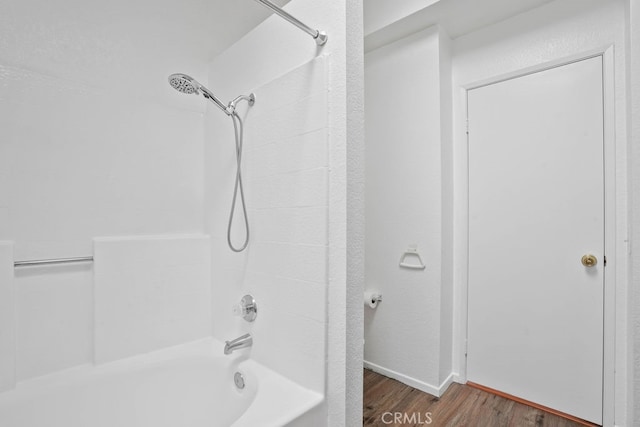 bathroom with bathing tub / shower combination and hardwood / wood-style flooring