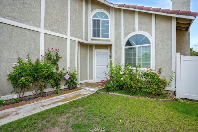 property entrance with a lawn