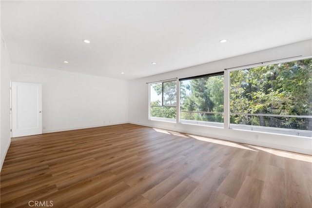 unfurnished room with hardwood / wood-style flooring