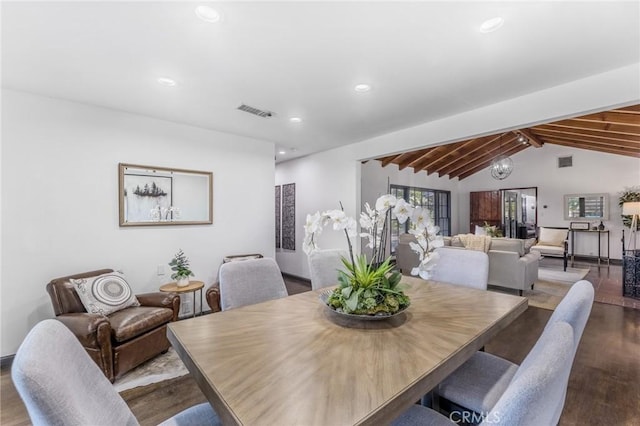 dining space with vaulted ceiling with beams, hardwood / wood-style floors, and a notable chandelier