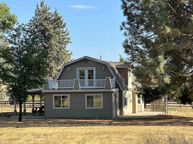 rear view of property with a patio, a balcony, and a carport