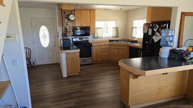 kitchen with sink, black appliances, kitchen peninsula, and dark hardwood / wood-style flooring