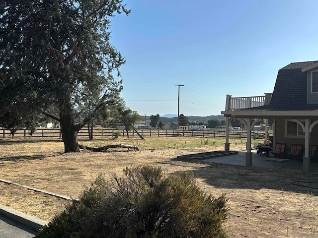 view of yard with a rural view and a patio