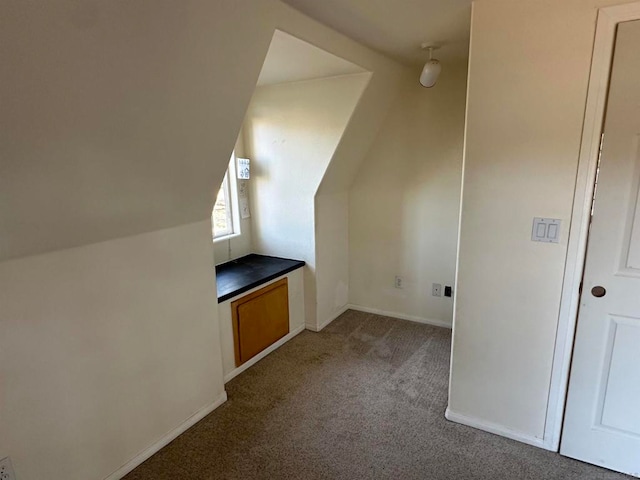 bonus room with lofted ceiling and carpet flooring