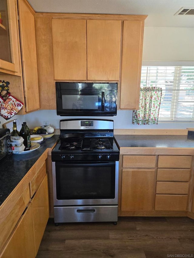 kitchen featuring gas range and dark hardwood / wood-style flooring