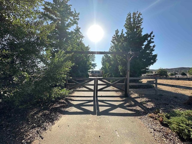 view of gate with a rural view