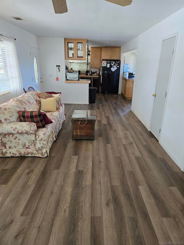 living room featuring ceiling fan and dark hardwood / wood-style floors