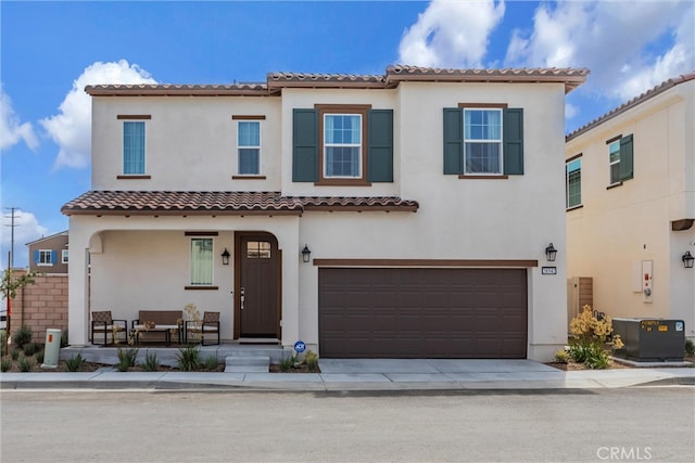 mediterranean / spanish-style house with a garage and central air condition unit