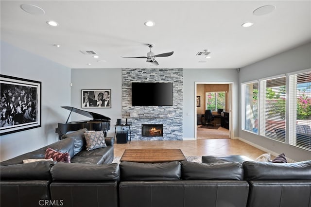 living room with ceiling fan, a fireplace, and light tile patterned floors