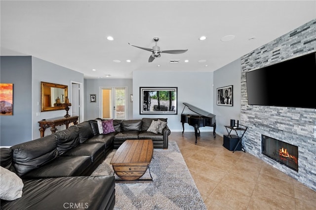 tiled living room featuring ceiling fan and a fireplace