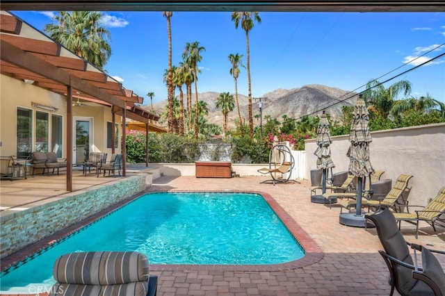 view of swimming pool featuring a mountain view and a patio