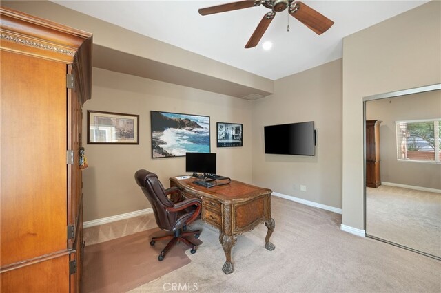 office space featuring light carpet and ceiling fan