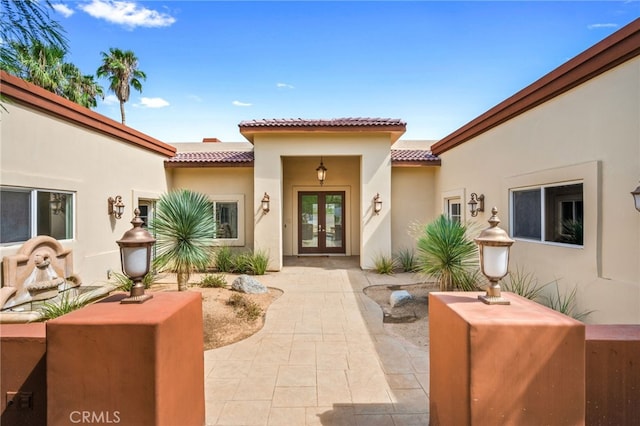 view of exterior entry with french doors and a patio