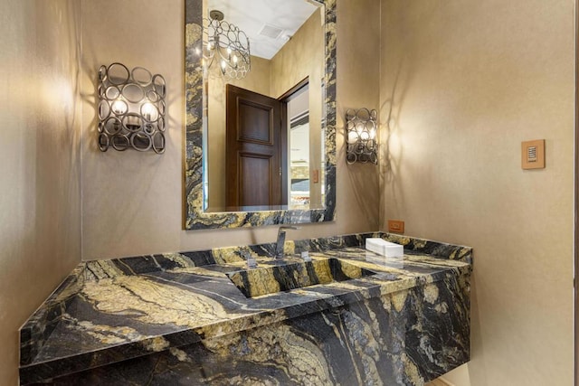 bathroom with vanity and a chandelier