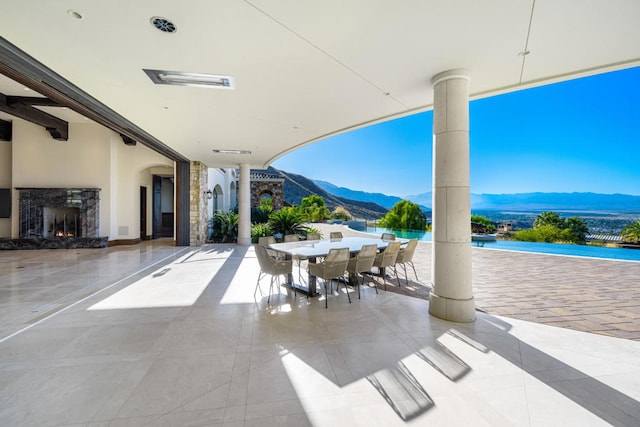 view of patio / terrace with a premium fireplace and a mountain view