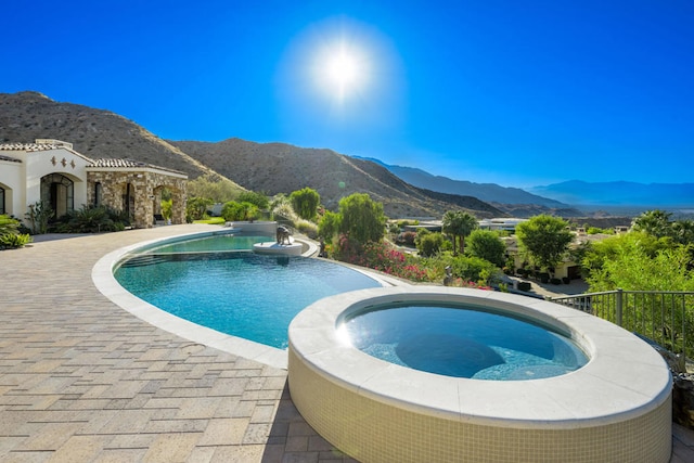 view of pool with a mountain view and an in ground hot tub