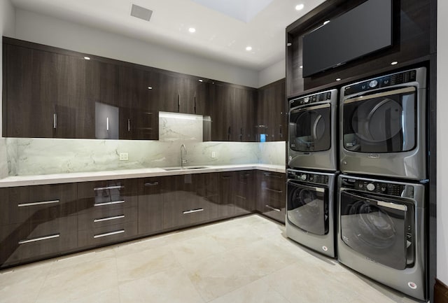 washroom featuring light tile patterned floors, stacked washer and dryer, washer and clothes dryer, and sink