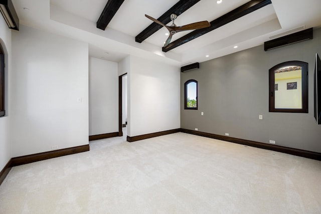 carpeted empty room featuring ceiling fan and beamed ceiling