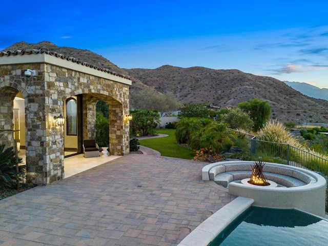 view of patio with a fire pit and a mountain view