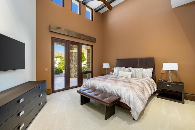 bedroom with access to exterior, light carpet, french doors, beam ceiling, and a high ceiling