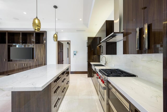 kitchen with pendant lighting, high end range, sink, decorative backsplash, and light stone countertops