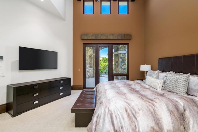 carpeted bedroom featuring a towering ceiling and access to outside