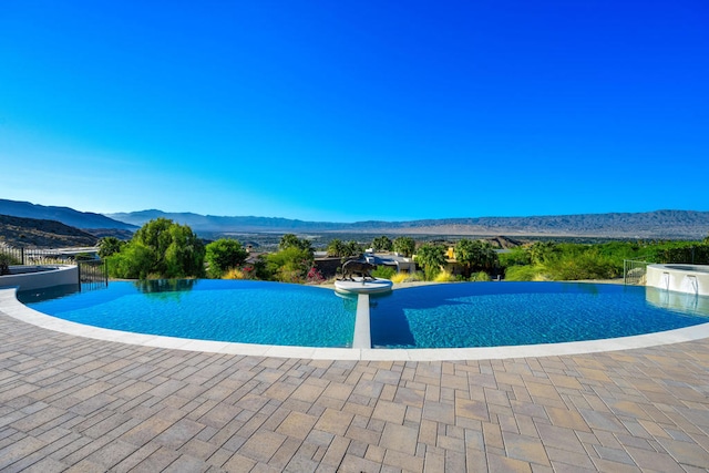 view of swimming pool with a patio area and a mountain view