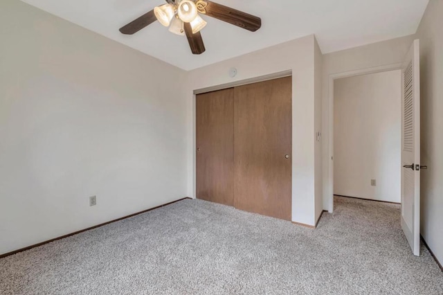 unfurnished bedroom with light carpet, a closet, and ceiling fan