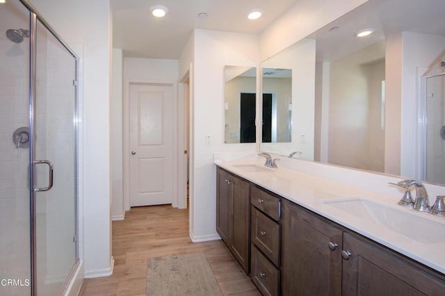 bathroom with walk in shower, vanity, and hardwood / wood-style flooring