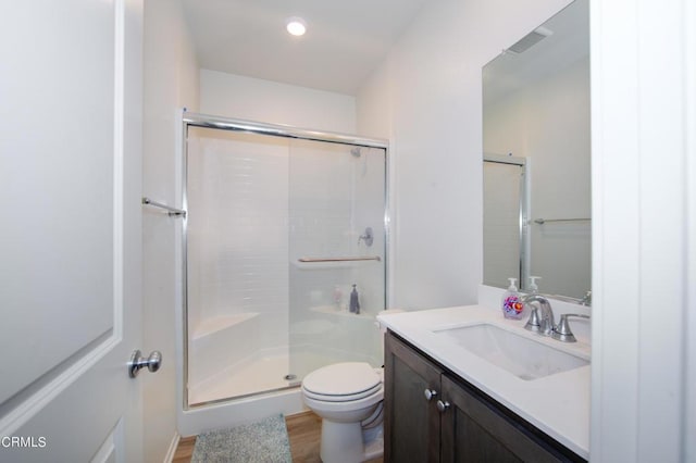 bathroom featuring wood-type flooring, vanity, toilet, and an enclosed shower