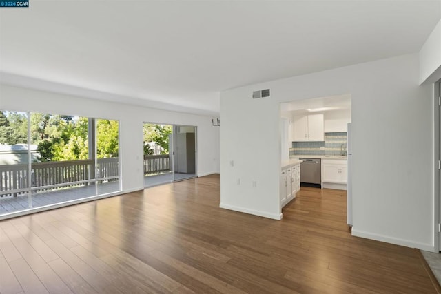 unfurnished living room with dark wood-type flooring and sink