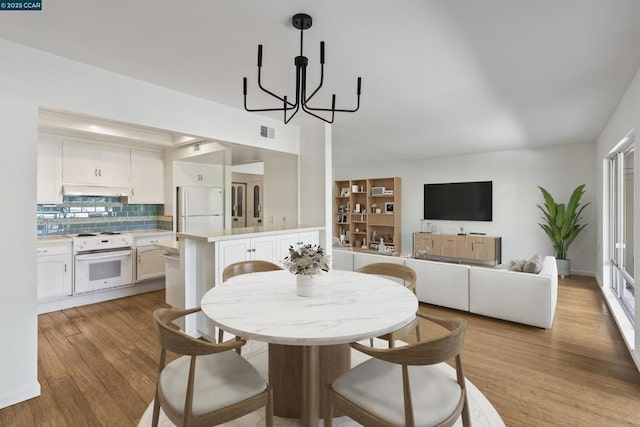 dining room with a notable chandelier and light hardwood / wood-style flooring