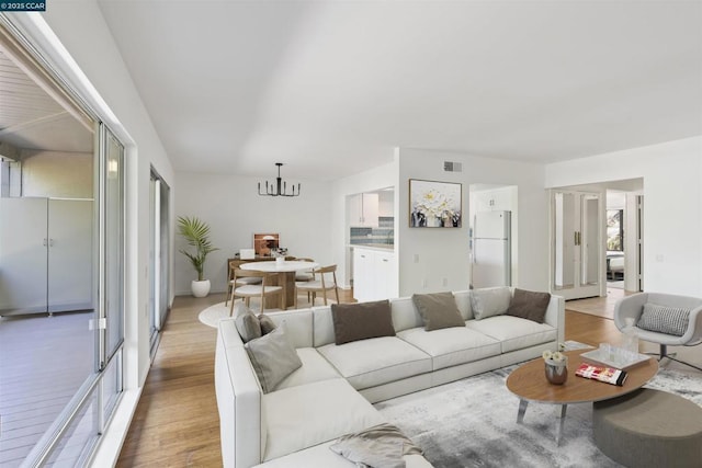 living room featuring an inviting chandelier and light hardwood / wood-style floors