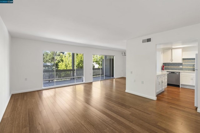 unfurnished living room featuring sink and hardwood / wood-style floors