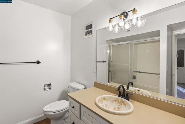 bathroom with toilet, an enclosed shower, and vanity