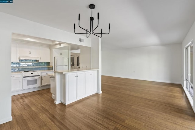 kitchen featuring white appliances, tasteful backsplash, an inviting chandelier, white cabinetry, and wood-type flooring