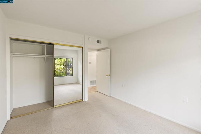 unfurnished bedroom with a closet and carpet floors