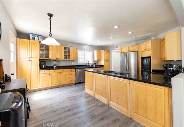 kitchen featuring black appliances, light brown cabinetry, light hardwood / wood-style flooring, and decorative light fixtures