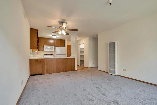 kitchen with ceiling fan, light colored carpet, white appliances, and kitchen peninsula