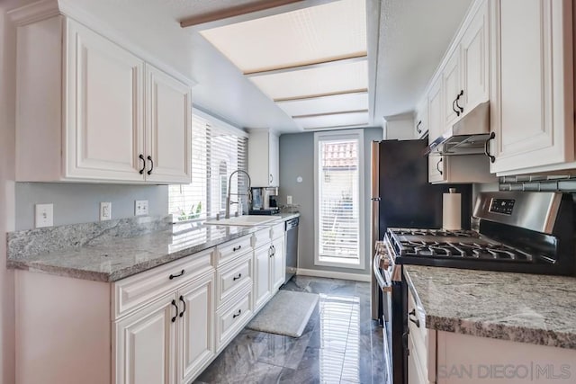 kitchen with appliances with stainless steel finishes, a healthy amount of sunlight, and white cabinets