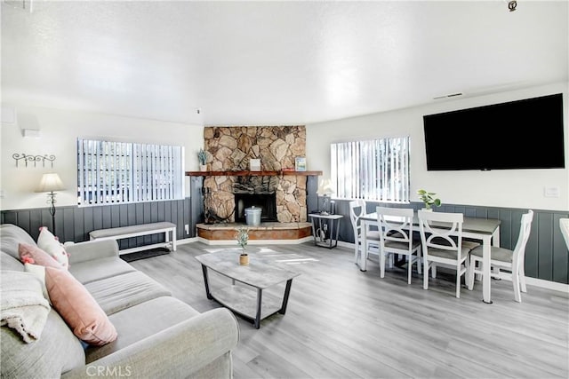 living room with plenty of natural light, light hardwood / wood-style floors, and a fireplace