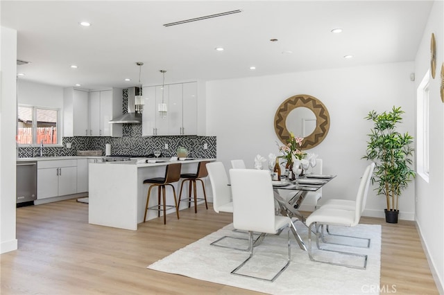 dining area with sink and light hardwood / wood-style flooring