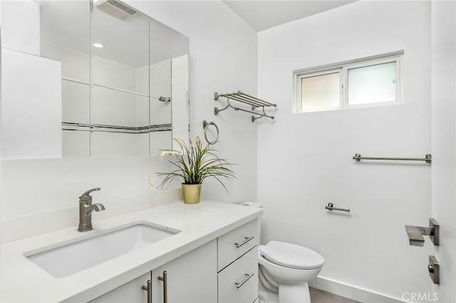 bathroom featuring walk in shower, vanity, and toilet