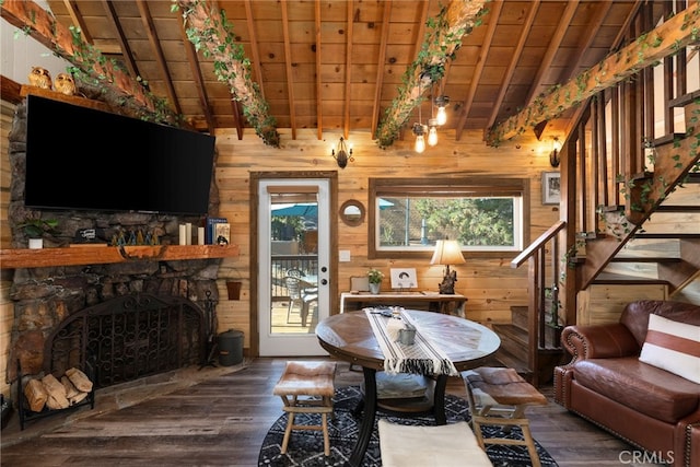 interior space with vaulted ceiling with beams, wooden walls, hardwood / wood-style flooring, wooden ceiling, and a fireplace