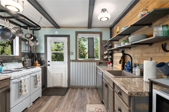 kitchen featuring sink, wood walls, light hardwood / wood-style flooring, white appliances, and light stone countertops