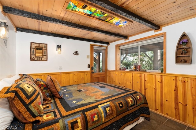 tiled bedroom with beamed ceiling, wood ceiling, and wood walls