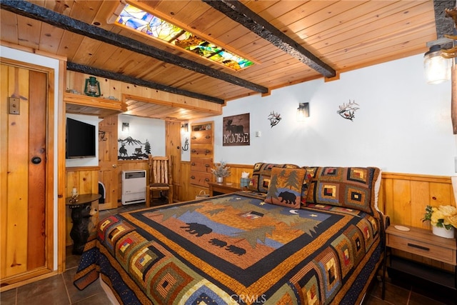 bedroom with beam ceiling, wood ceiling, wood walls, and dark tile patterned floors