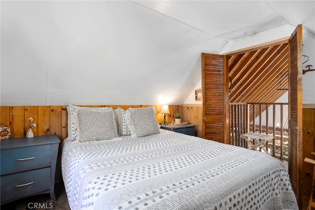 bedroom with wooden walls and vaulted ceiling