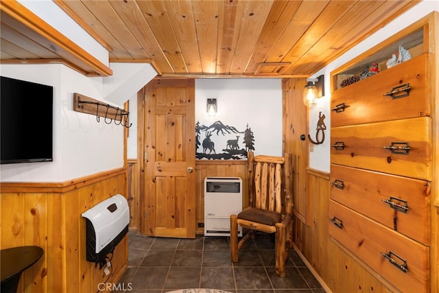 interior space with wood ceiling, wooden walls, and heating unit