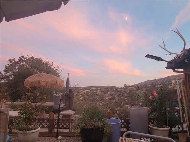 patio terrace at dusk featuring a mountain view